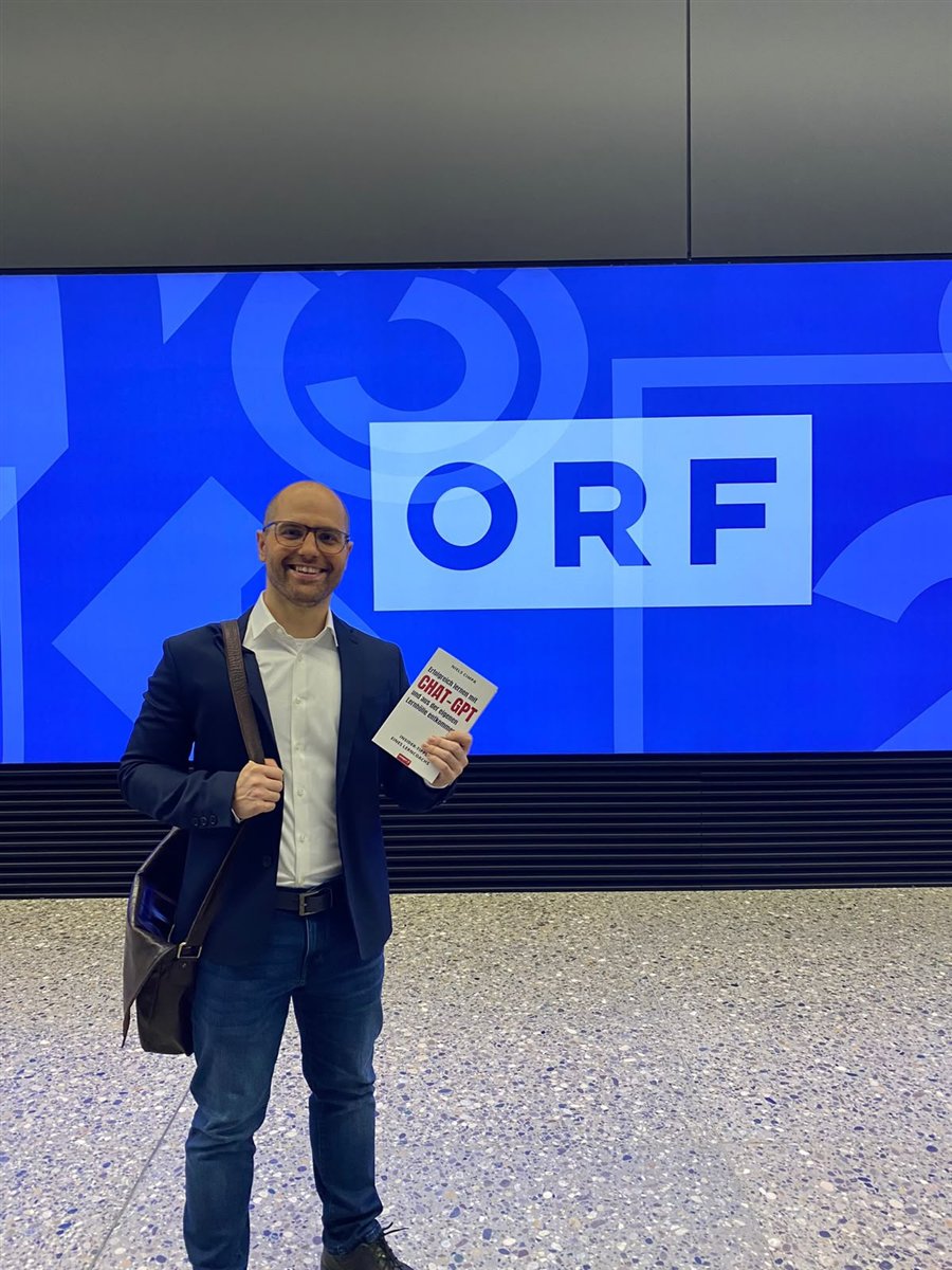 Niels Cimpa mit seinem Buch „Erfolgreich lernen mit ChatGPT“ vor dem ORF-Logo im ORF-Zentrum