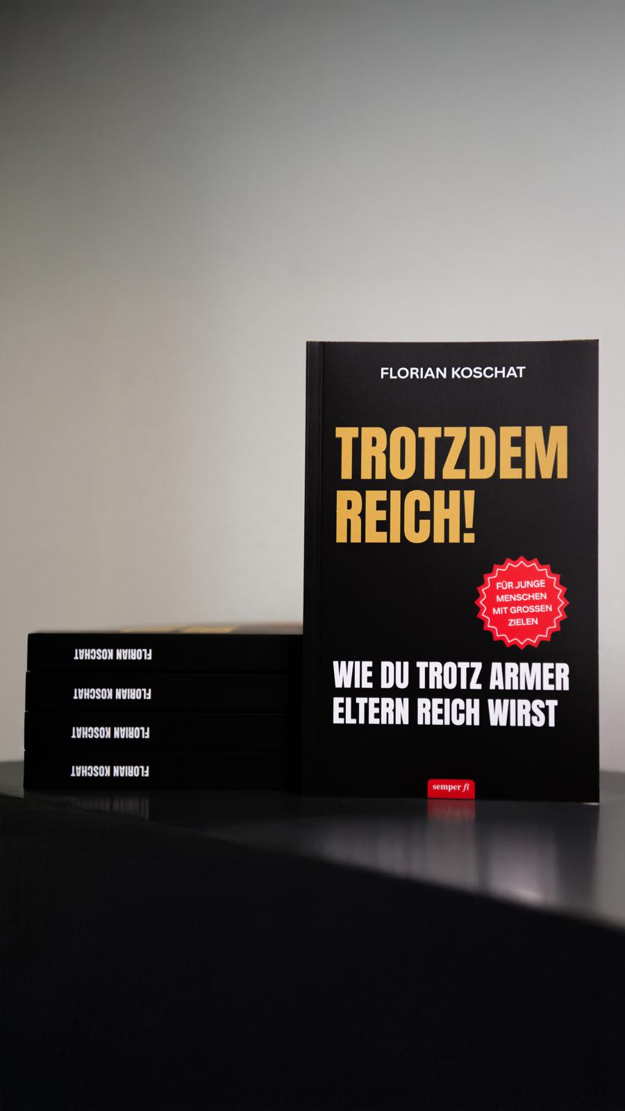 „Trotzdem reich!“ aufrecht neben einem Stapel weiterer Exemplare